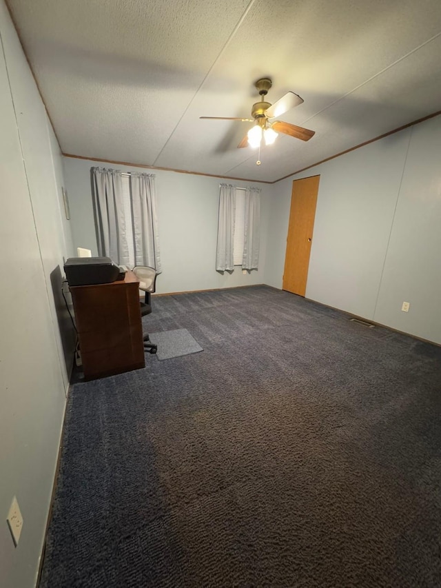 basement featuring ceiling fan, a textured ceiling, and carpet