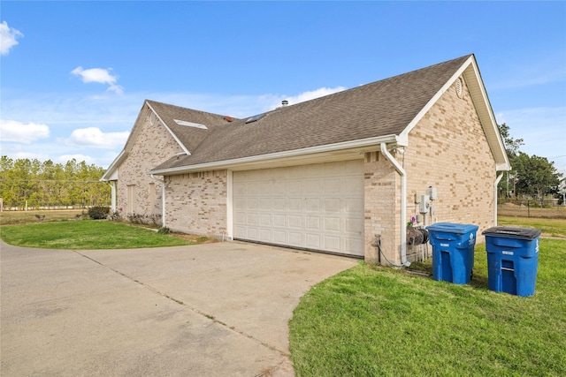 view of side of property featuring a garage and a yard