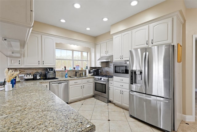 kitchen featuring sink, white cabinets, light tile patterned floors, light stone counters, and stainless steel appliances