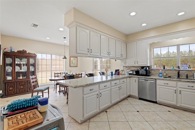 kitchen with dishwasher, sink, white cabinets, kitchen peninsula, and light stone countertops