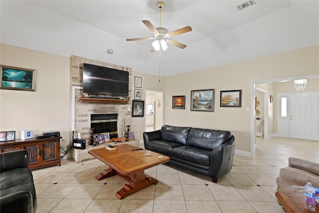 tiled living room with lofted ceiling, a brick fireplace, and ceiling fan