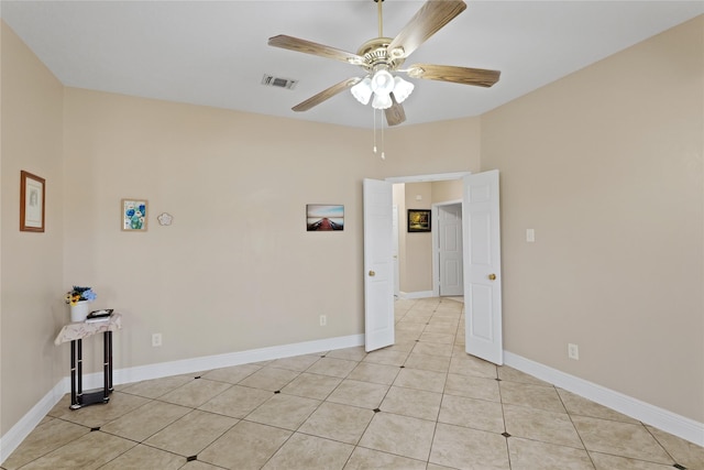 tiled spare room with ceiling fan