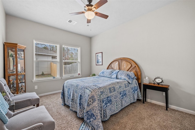 carpeted bedroom with visible vents, a ceiling fan, and baseboards