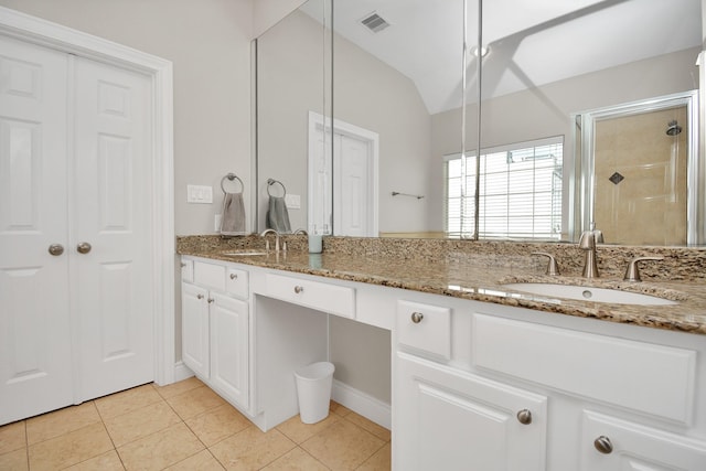 bathroom featuring vanity, tile patterned flooring, lofted ceiling, and walk in shower