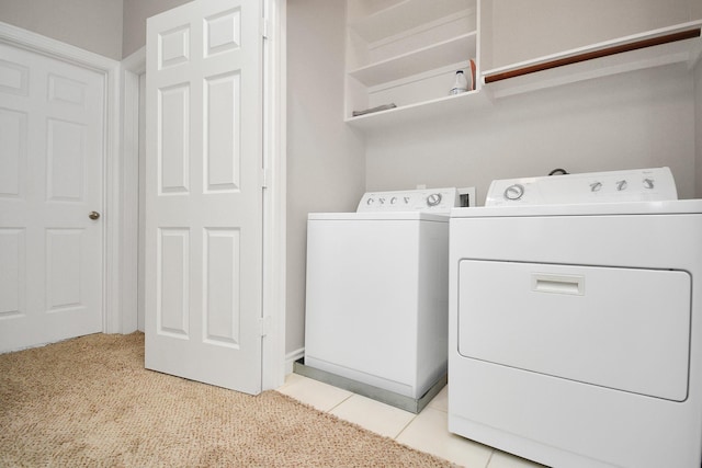 laundry room with washing machine and dryer and light tile patterned floors