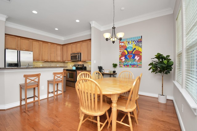 dining room featuring ornamental molding, a chandelier, and light wood-type flooring