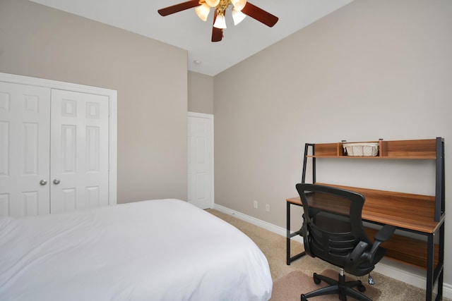 bedroom featuring light colored carpet, ceiling fan, and a closet