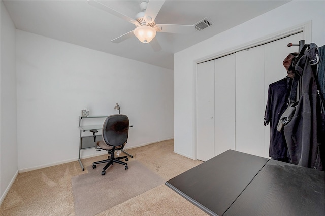 carpeted office space featuring ceiling fan