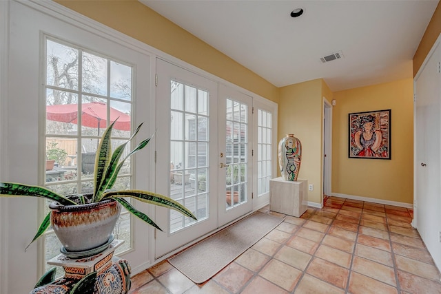 doorway featuring a healthy amount of sunlight, light tile patterned floors, and french doors