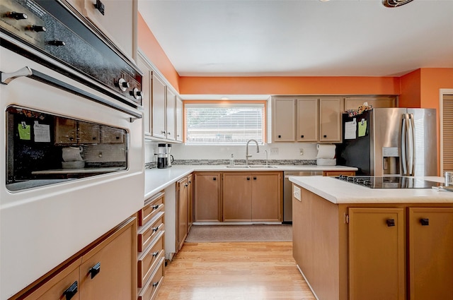 kitchen with stainless steel appliances, sink, and light wood-type flooring