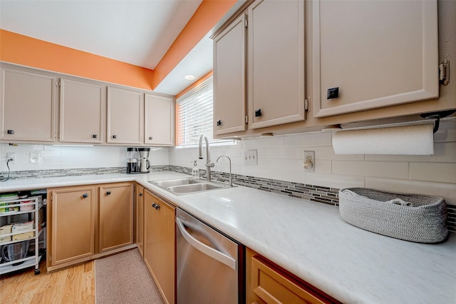 kitchen with stainless steel dishwasher, sink, decorative backsplash, and light hardwood / wood-style flooring