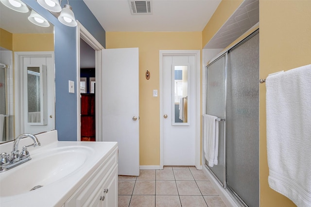 bathroom with vanity, a shower with door, and tile patterned flooring