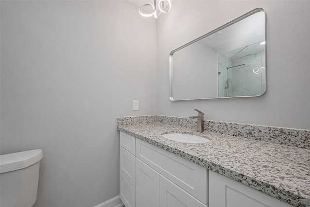 bathroom featuring vanity, walk in shower, and toilet