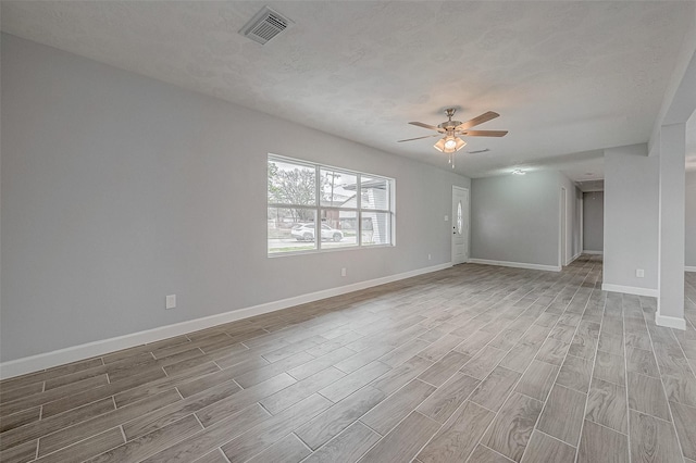 spare room with a textured ceiling, ceiling fan, and light hardwood / wood-style flooring