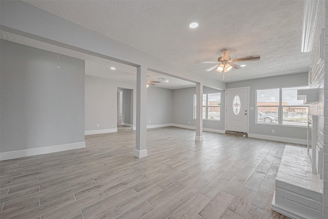 interior space with a textured ceiling and ceiling fan