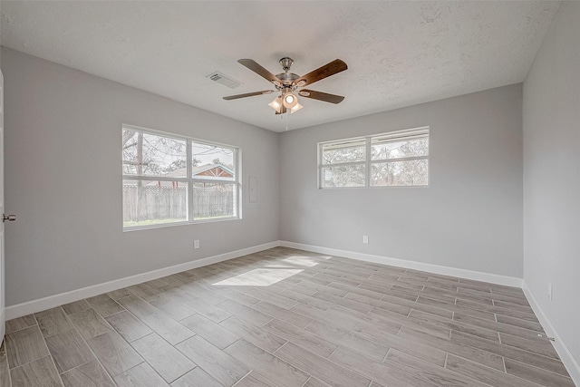 empty room featuring ceiling fan, light hardwood / wood-style floors, and a textured ceiling