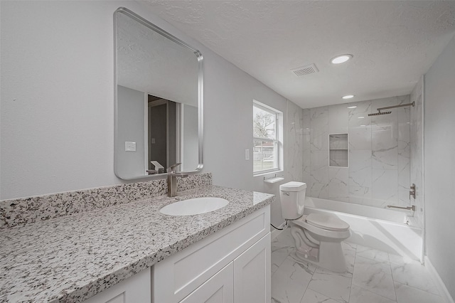 full bathroom featuring vanity, tiled shower / bath, a textured ceiling, and toilet