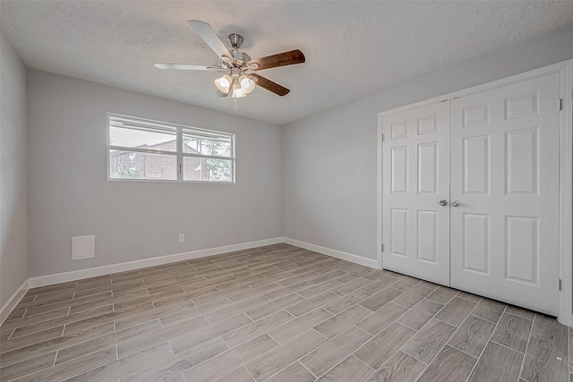 unfurnished bedroom with a textured ceiling, a closet, and ceiling fan