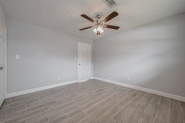 empty room with a textured ceiling and ceiling fan