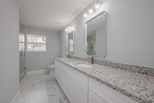 bathroom featuring vanity, a shower with shower door, toilet, and a textured ceiling