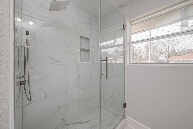 bathroom featuring a shower with door