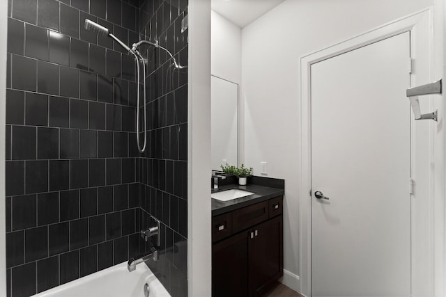 bathroom featuring tiled shower / bath combo and vanity