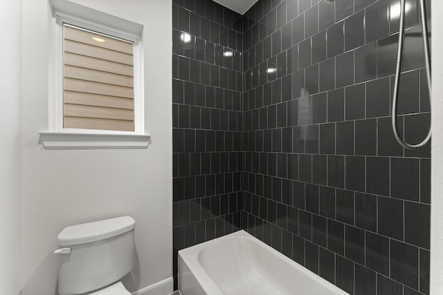 bathroom featuring toilet and tiled shower / bath combo