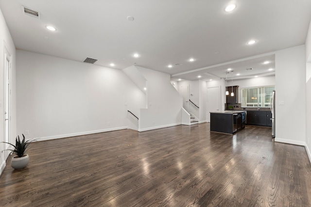 unfurnished living room featuring dark hardwood / wood-style flooring and sink