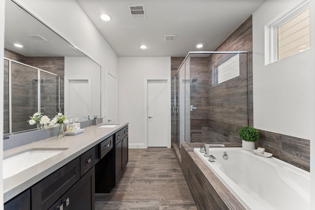 bathroom featuring vanity, hardwood / wood-style floors, and plus walk in shower