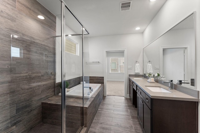 bathroom with vanity, hardwood / wood-style flooring, and shower with separate bathtub