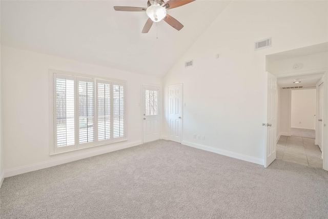 spare room featuring ceiling fan, light carpet, and high vaulted ceiling