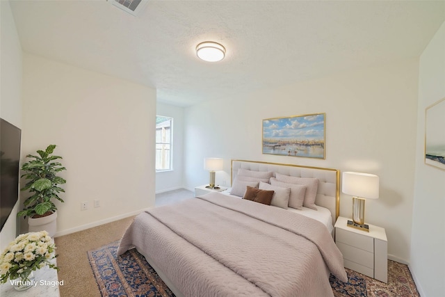 bedroom featuring carpet floors and a textured ceiling