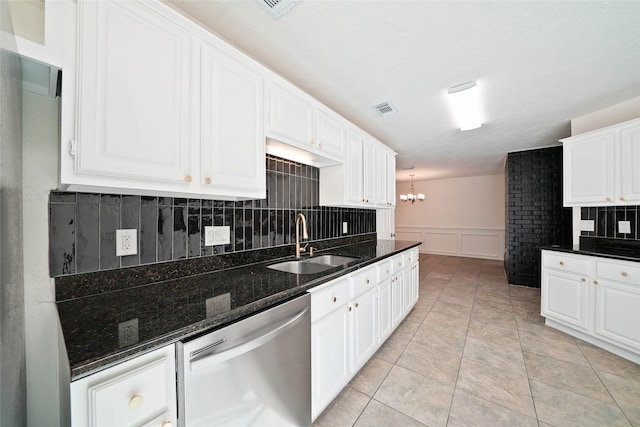 kitchen with white cabinetry, dishwasher, sink, and dark stone countertops