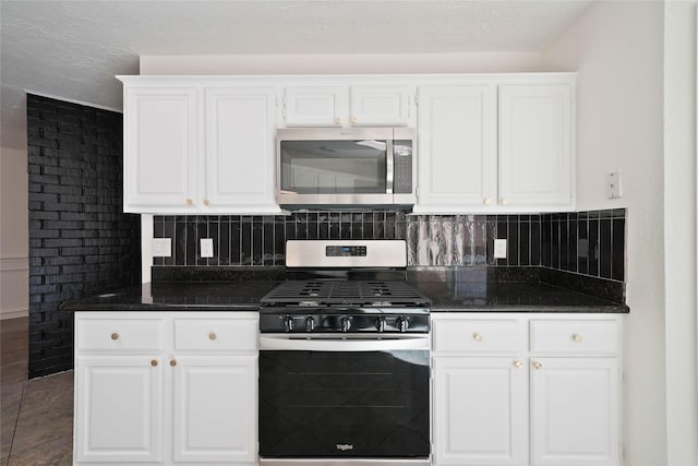 kitchen featuring white cabinetry, dark stone countertops, and appliances with stainless steel finishes