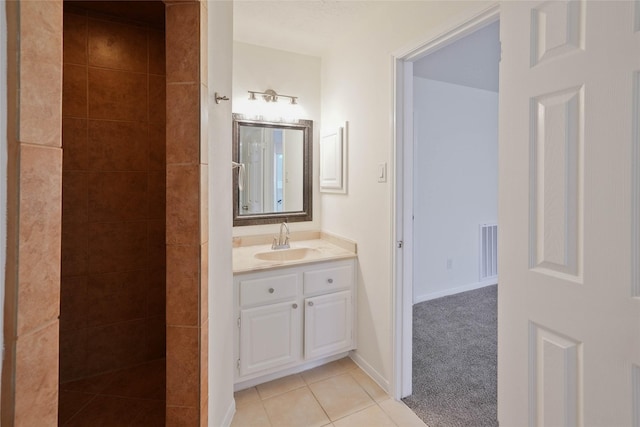 bathroom featuring vanity, tile patterned floors, and tiled shower