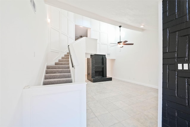 tiled entryway with a fireplace and ceiling fan