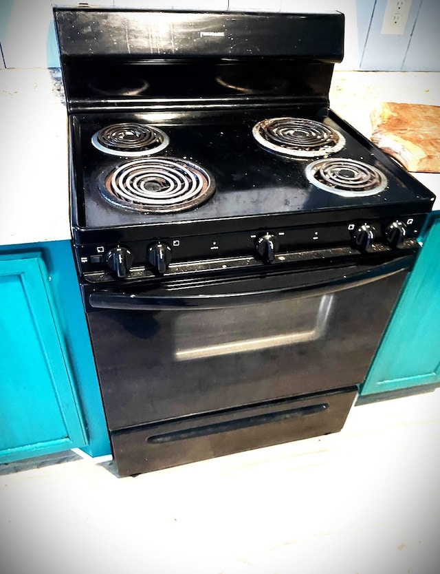 details featuring blue cabinets and black / electric stove