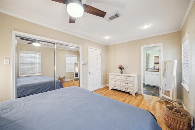 bedroom with ensuite bathroom, ceiling fan, light hardwood / wood-style floors, crown molding, and a closet