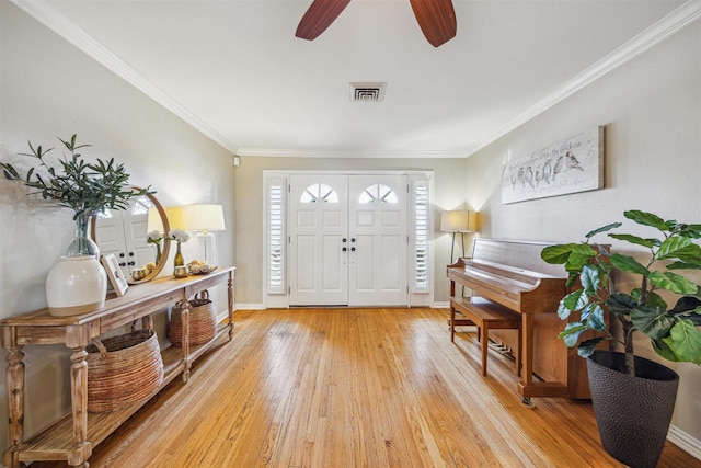 entryway featuring crown molding, ceiling fan, and light wood-type flooring