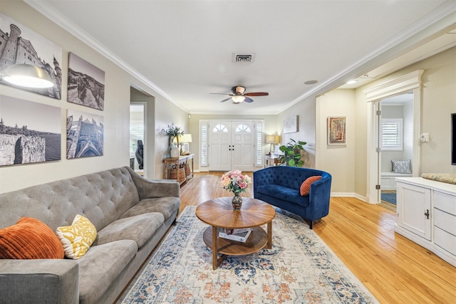 living room with ornamental molding, ceiling fan, and light hardwood / wood-style flooring