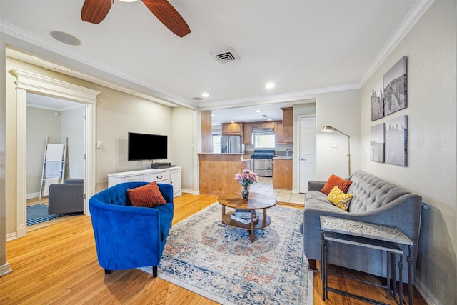 living room with crown molding, light hardwood / wood-style floors, and ceiling fan