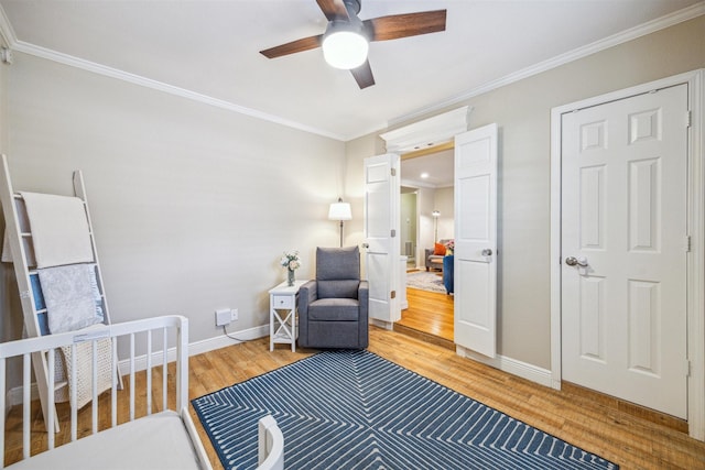 living area with ceiling fan, ornamental molding, and wood-type flooring