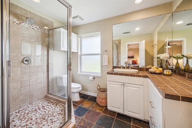 bathroom with vanity, toilet, and a shower with shower door