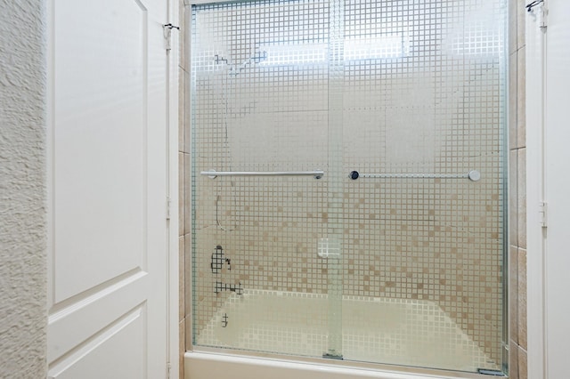 bathroom with shower / bath combination with glass door