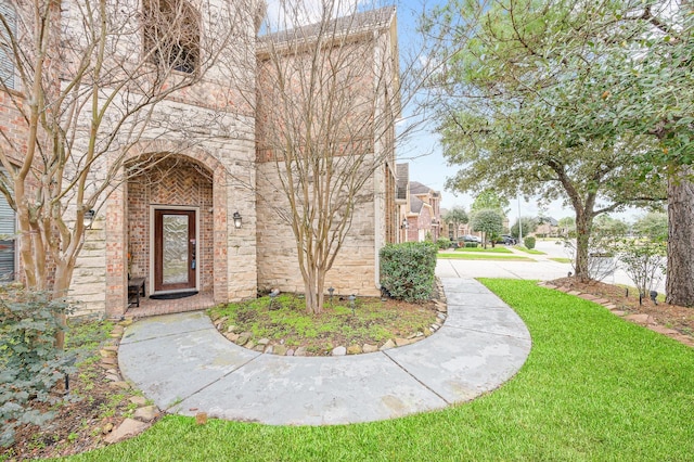 view of exterior entry featuring a yard