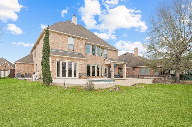 rear view of house featuring french doors, cooling unit, a patio area, and a lawn