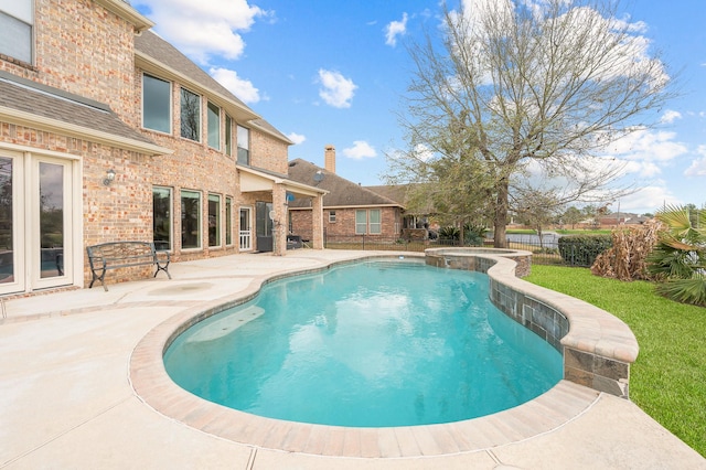 view of pool with an in ground hot tub and a patio