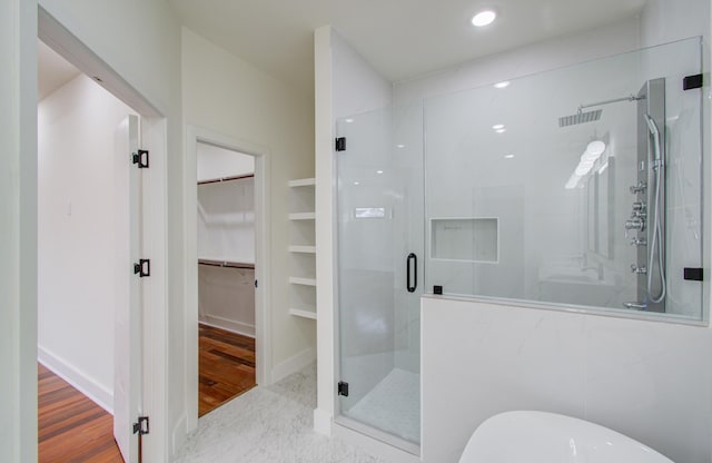 bathroom with independent shower and bath and hardwood / wood-style flooring