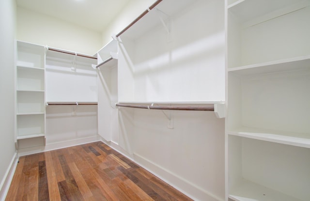 walk in closet with dark hardwood / wood-style floors