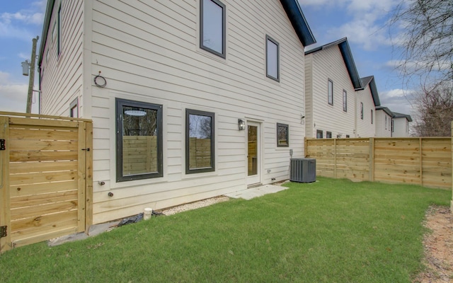 rear view of property featuring cooling unit and a yard